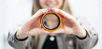 Mitarbeitern hält Hydraulikdichtung mit beiden Händen umschlossen in die Kamera. Der Fokus liegt auf der Dichtung und den Händen